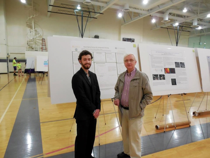 Thomas Richardson (left) discusses his physics presentation with Dr. Bill Baker (right). Photo courtesy of Dr. David Moffett