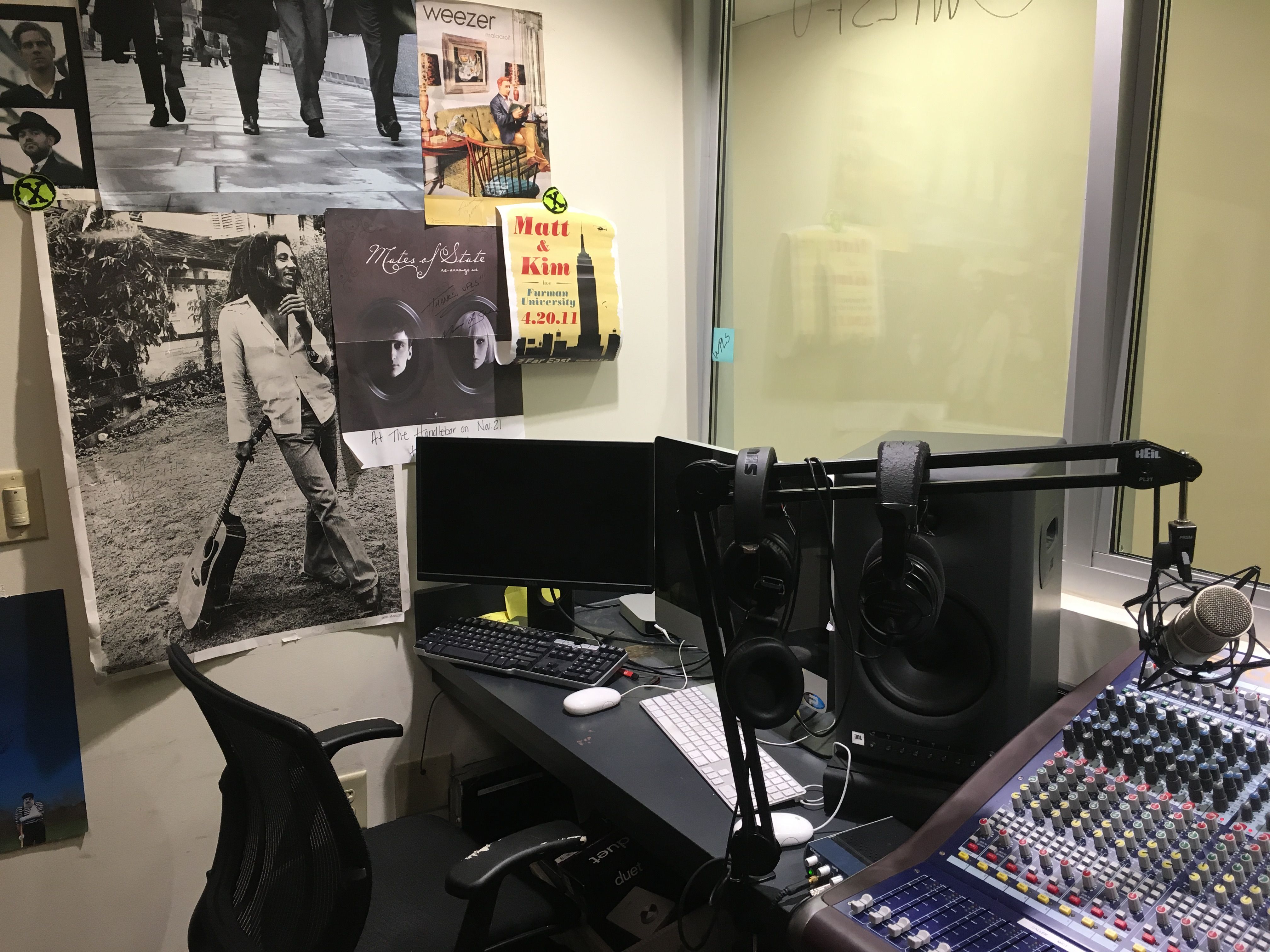 Computers, speakers, headphones, and microphones on the table in the old WPLS office